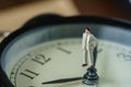 business or time countdown concept as miniature businessman figure standing on alarm clock