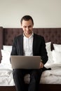 Business tourist working on laptop in hotel room Royalty Free Stock Photo