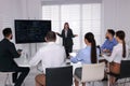 Business trainer near interactive board in meeting room during presentation