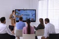 Business trainer using interactive board in meeting room during presentation Royalty Free Stock Photo