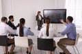 Business trainer using interactive board in meeting room during presentation