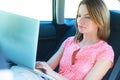 Business travel: busy businesswoman with laptop in car Royalty Free Stock Photo