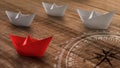 Business or travel concept: a group of white paper ships heading in one direction and one red paper ship individual pointing in