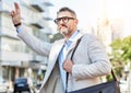 Business, travel and man with hand for taxi, attention or hail in city on morning work commute. Bus, stop and guy Royalty Free Stock Photo