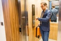 Businessman with luggage looking at smart watch in elevator Royalty Free Stock Photo