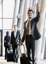 Business traveler pulling suitcase and gesturing Royalty Free Stock Photo