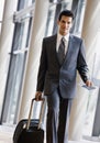 Business traveler pulling suitcase and passport