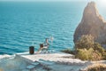 Woman sitting on chair and typing on laptop, seascape on background. Business travelling and distance work concept