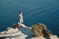 Business travelling and dream job concept. Woman in headphones holding laptop and suitcase. Seascape on background. Royalty Free Stock Photo