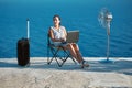 Business travelling and remote work concept. Life work balance, freelance idea. Woman working with laptop on beach.
