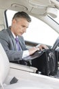 Businessman searching in bag while sitting in car