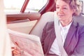 Mature businesswoman reading newspaper while sitting in car Royalty Free Stock Photo