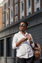 African american woman with backpack walking outdoor and talking on mobile phone Royalty Free Stock Photo