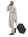 Business trip. A young AfricanAmerican businessman speaking on his phone while walking with luggage.