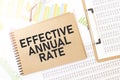 Business up graph on a sheet of craft colour Notepad with EFFECTIVE ANNUAL RATE sign. Notepad on desk with financial documentation Royalty Free Stock Photo
