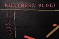 Business Vlog! written with color chalk. Supported by an additional services. Blackboard concept