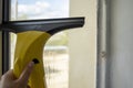 Business washing and cleaning windows. The yellow device collects drops of water and cleans the window. Wiper in the hands of a gi