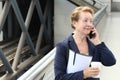 Business woman in the airport or train subway metro station making a phone call with smartphone Royalty Free Stock Photo