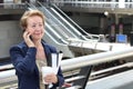 Business woman in the airport or train subway metro station making a phone call with smartphone Royalty Free Stock Photo