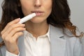 Business woman applying hygienical chapstick to her lips to prevent dryness, chapping in cold season