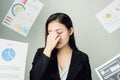 Business woman in a black suit is throw away a lot of paperwork and the documents are blown overhead. showing signs of stress.