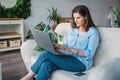 Business woman in blue shirt typing in laptop.Online conference.Remote work at home office sitting on couch.Message,dating,meeting