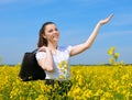 Business woman with briefcase relaxing in flower field outdoor under sun. Young girl in yellow rapeseed field. Beautiful spring la Royalty Free Stock Photo