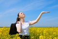 Business woman with briefcase relaxing in flower field outdoor under sun. Young girl in yellow rapeseed field. Beautiful spring la Royalty Free Stock Photo