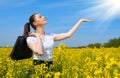 Business woman with briefcase show palm to sun. Young girl in yellow flower field. Beautiful spring landscape, bright sunny day, r Royalty Free Stock Photo