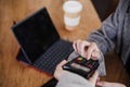 Business woman in cafe doing contact less payment, introducing secret number. digital tablet besides Royalty Free Stock Photo