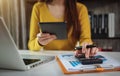 Business woman calculates financials with graph paper on the table on the cost of home office.