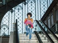 Business woman in casual clothes looks at her mobile phone while going down a stairs Royalty Free Stock Photo