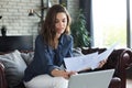 Business woman checking paper documents in home office,working on laptop from home Royalty Free Stock Photo