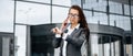 A business woman checks the time and talking on the phone in the city during a working day waiting for a meeting. Discipline and Royalty Free Stock Photo