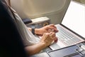 Business woman commercial plane passenger using laptop on board for working while sitting in airplane. Traveling and technology Royalty Free Stock Photo