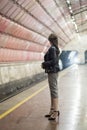 Business woman with a cup of coffee at subway station and train. Beautiful girl in sunglasses and a jacket at the subway station. Royalty Free Stock Photo