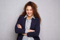 Business woman with curly hair smiling against gray background Royalty Free Stock Photo