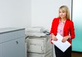 Business woman with documents standing next to printer Royalty Free Stock Photo
