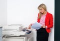 Business woman with documents standing next to printer Royalty Free Stock Photo