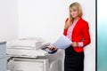 Business woman with documents standing next to printer Royalty Free Stock Photo