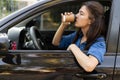 Business woman drinking coffee in the car while sitting behind the wheel in the driver& x27;s seat Royalty Free Stock Photo