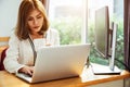 Business woman drinking a cup of coffee and using her laptop Royalty Free Stock Photo