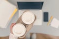 Business woman drinks coffee from paper cups while working on the laptop in an office. Royalty Free Stock Photo