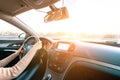 Business woman driving car. Travel car trip on road at sunset. Happy young woman have fun ride inside vehicle in winter sunny day Royalty Free Stock Photo