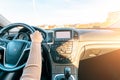 Business woman driving car. Travel car trip on road at sunset. Happy young woman have fun ride inside vehicle in winter sunny day Royalty Free Stock Photo