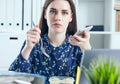 Business woman eating lunch at her workplace looking at the laptop screen. Folders with documents in the foreground Royalty Free Stock Photo