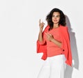 Business woman in elegant coral shirt, jacket and white pants stands gesturing talking arguing reasoning