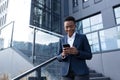 Business woman enjoys cellphone fun and smiling, African American boss businesswoman outside office in business suit Royalty Free Stock Photo