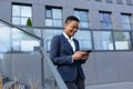 Business woman enjoys cellphone fun and smiling, African American boss businesswoman outside office in business suit Royalty Free Stock Photo