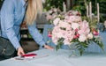 Business woman florist decorates table notepad smartphone